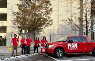 five window cleaners posing in front of a building and next to red fish window cleaning truck