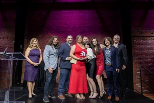 owner cole robinson and her team posing for picture where they won small business of the year