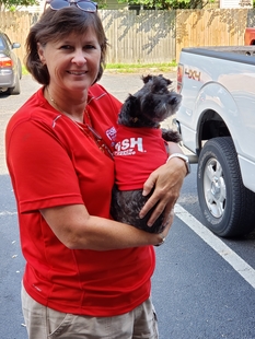 Owner, Kim Waller, Holding a Dog Wearing a Fish Window Cleaning Shirt