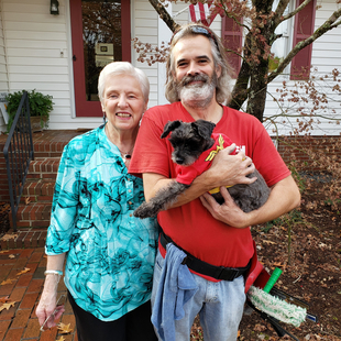 Fish Window Cleaner Holding Small Dog with Recipient of Free Window Cleaning for Breast Cancer Awareness Month