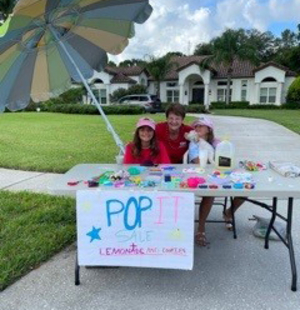 Owner Kim Lowe with Two Local Children at their Pop-It Stand