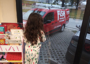 Little Girl Cleaning Window with Branded Vehicle Parked Outside