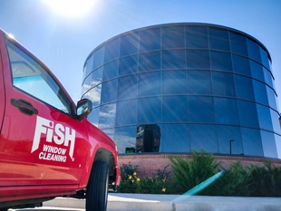 Side of Logo'd Vehicle in Front of Circular Shaped Building of Windows