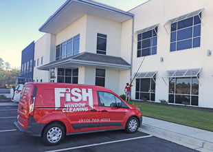 Fish Window Cleaning Branded Van and Cleaner Cleaning 2-Story Commercial Building