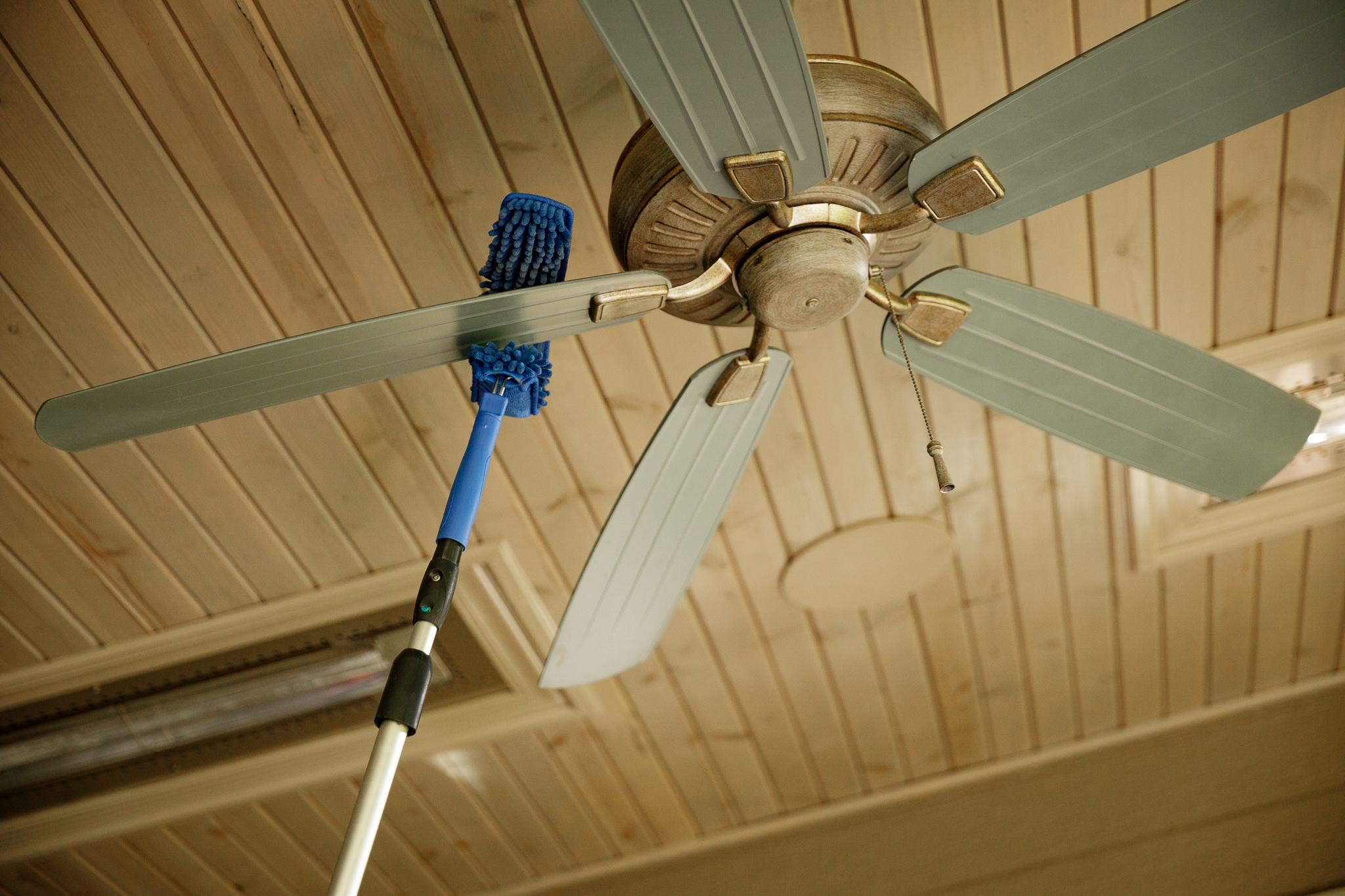 Ceiling Fan Being Cleaned with a Blue Pad