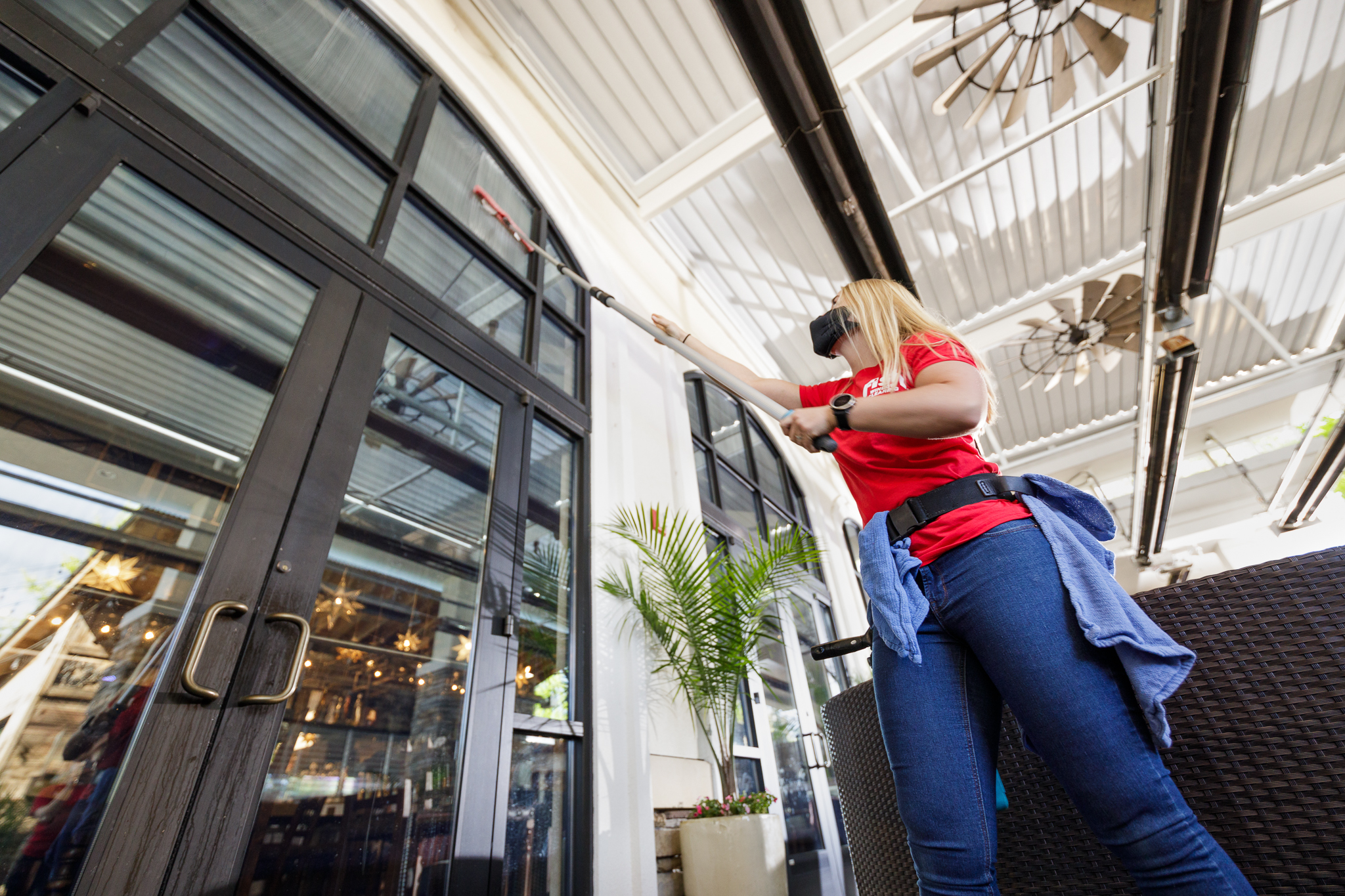 FISH Window Cleaner Cleaning Restaurant Windows with a Pole Wearing a Mask