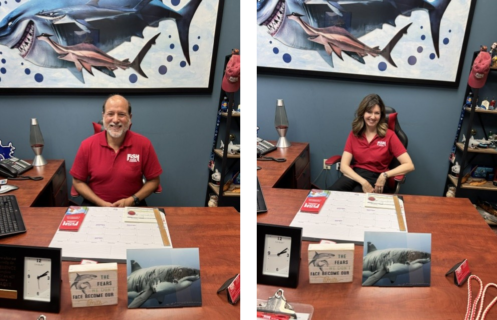 Man in red FISH Window Cleaning shirt sitting behind desk