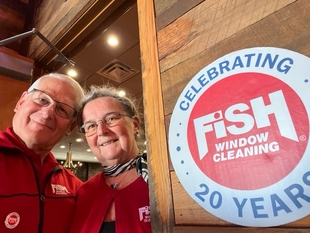 owners david and joanne musteric next to their celebrating 20 years with fish sign